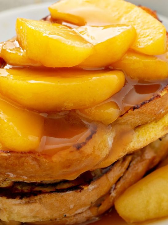 Stack of apple cinnamon French toast drizzled with syrup.